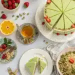 A dessert table featuring Tropical Pistachio Bliss Cake and fresh sides