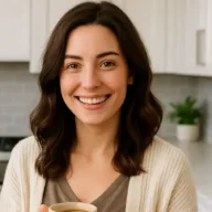Nora enjoying a warm cup of coffee in her kitchen Smiling woman holding a cup of coffee in a bright, modern kitchen