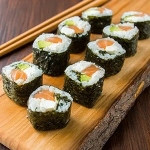 Homemade sushi rolls with salmon, avocado, and cream cheese served with soy sauce and wasabi